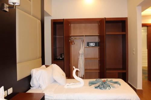 a room with a bed with a swan on it at Royal Jewel Al Raml Hotel in Alexandria