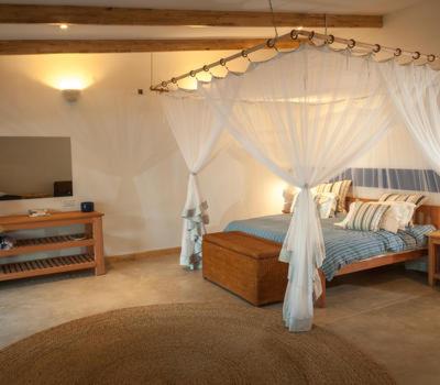 1 dormitorio con 1 cama con dosel en Sunbird Chintheche, en Nkhata Bay
