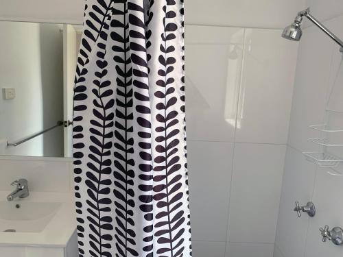 a bathroom with a black and white shower curtain at Baths Motel Moree in Moree