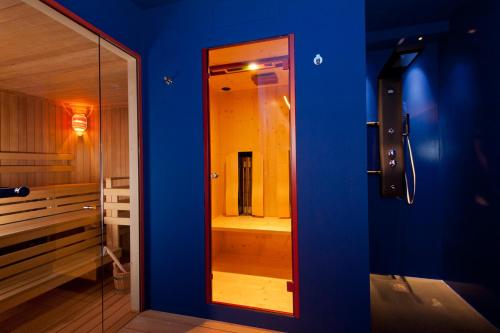 a bathroom with a mirror in a blue wall at Hotel Ansitz Kematen ***S in Collalbo