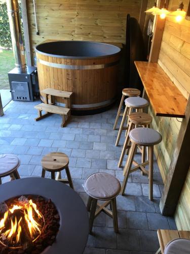 un patio con vasca idromassaggio, sgabelli e un braciere di Cottage Fleuri a Koksijde