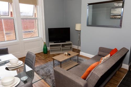 a living room with a couch and a television at Tyne Apartments in Gateshead