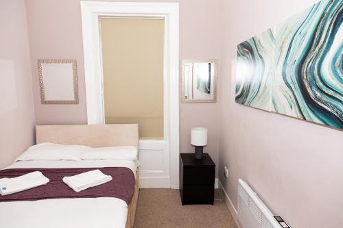 a bedroom with a bed and a painting on the wall at Tyne Apartments in Gateshead