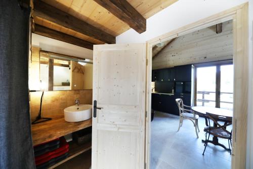 a bathroom with a sink and a table at Les Chalots de Gérardmer, Gîte 1, Classé 3 in Gérardmer