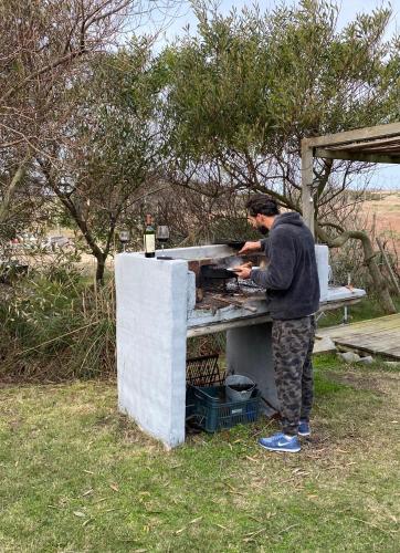 a man is preparing food in an outdoor oven at Loft de Mar in José Ignacio