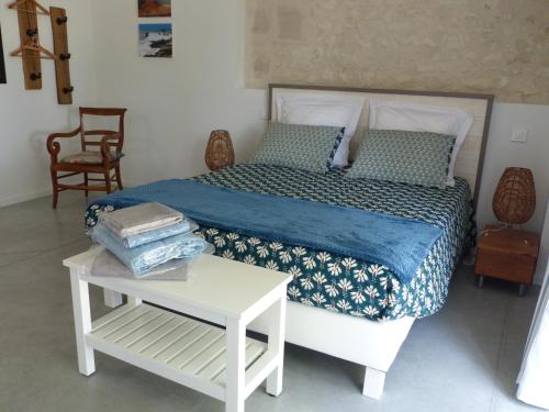 um quarto com uma cama e uma mesa branca com uma cama sidx em L'Alambic De L'Estuaire em Saint-Fort-sur-Gironde
