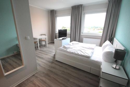 een slaapkamer met een bed, een bureau en een spiegel bij Schlafhaus Dünenweg 16 in Heringsdorf