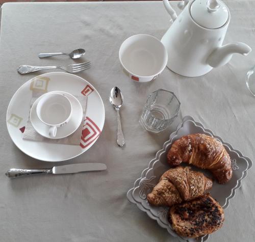 - une table avec un plateau de pâtisseries et une tasse de café dans l'établissement Cascina Spazio Indaco, à Castagnole Monferrato