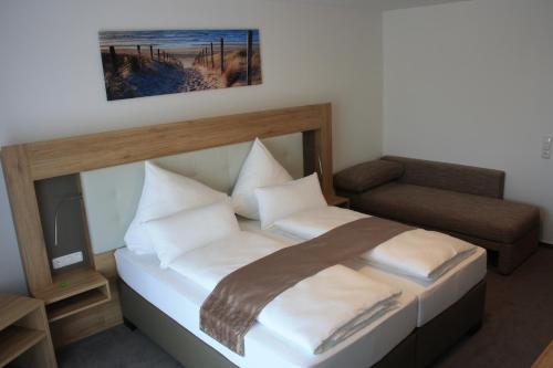 a bedroom with a bed and a chair and a television at Zum alten Bahnhof in Blunk