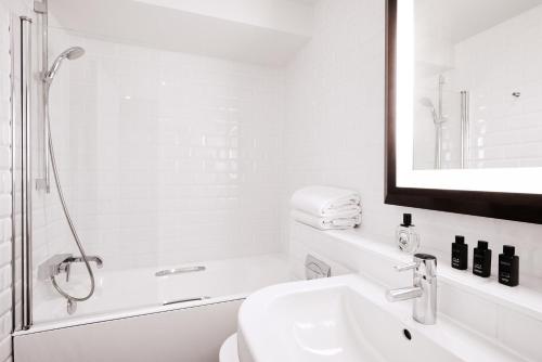 uma casa de banho branca com um lavatório e um espelho em Plaza Tour Eiffel em Paris