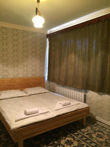 a bedroom with a bed with two towels on it at Apple Tree Family Home (ECO) in Dzorakap