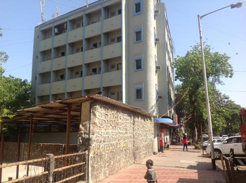 a boy walking down a street in front of a building at Pals Hotel in Mumbai