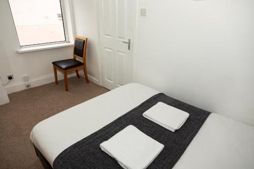 a bedroom with a bed and a chair and a window at South Shields Central in South Shields