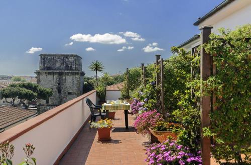 un balcone con tavolo e fiori di Hotel Lupori a Viareggio