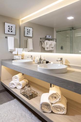 a bathroom with two sinks and towels on a shelf at Palazzo Lakeside Hotel in Kissimmee