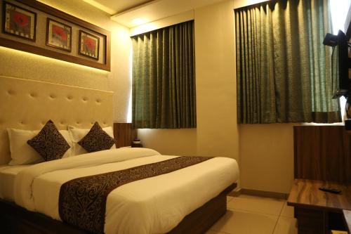 sypialnia z dużym łóżkiem i oknem w obiekcie HOTEL RK PALACE w mieście Ahmadabad