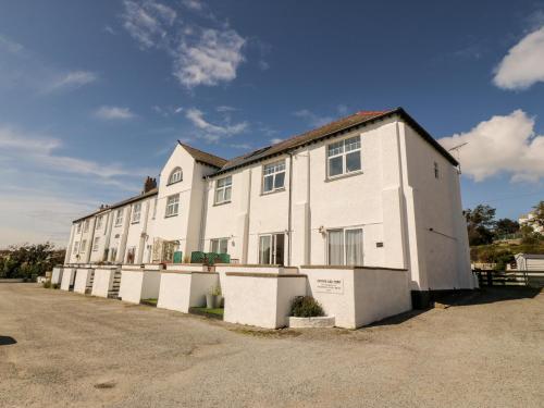 a large white building with a lot of windows at Ketch Cottage in Holyhead