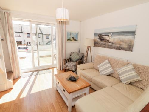 a living room with a couch and a table at Ketch Cottage in Holyhead