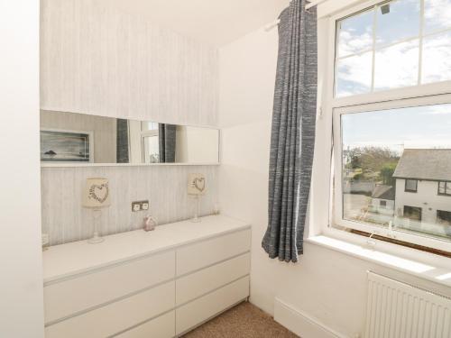 a bathroom with a sink and a window at Ketch Cottage in Holyhead