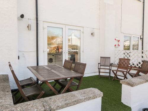 a wooden table and chairs on a patio at Ketch Cottage in Holyhead