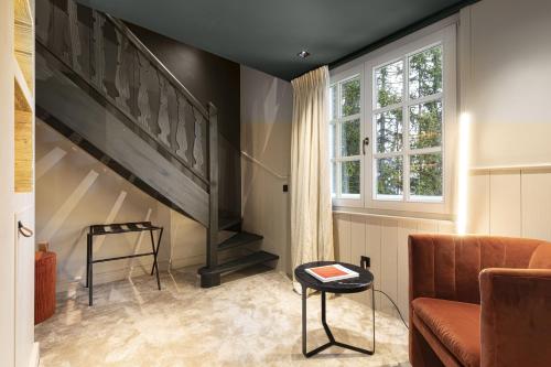 a living room with a staircase and a couch at Hotel Le Chabichou in Courchevel