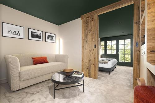 a living room with a couch and a bed at Hotel Le Chabichou in Courchevel