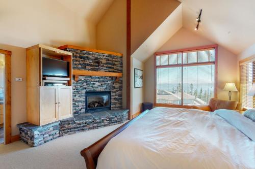 ein Schlafzimmer mit großem Bett und Kamin in der Unterkunft Northern Star in Big White