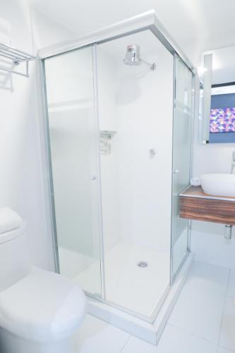 a bathroom with a glass shower and a sink at Hotel Dwana in Mazatlán