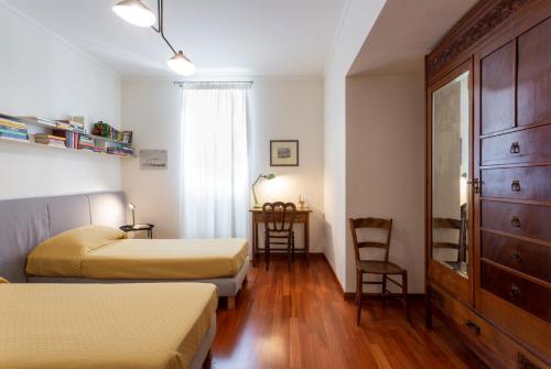 una camera d'albergo con 2 letti e una scrivania di Suite La Pergola - Centro Storico a Catania
