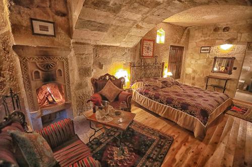 a bedroom with a bed and a fireplace at Traveller's Cave Hotel in Goreme