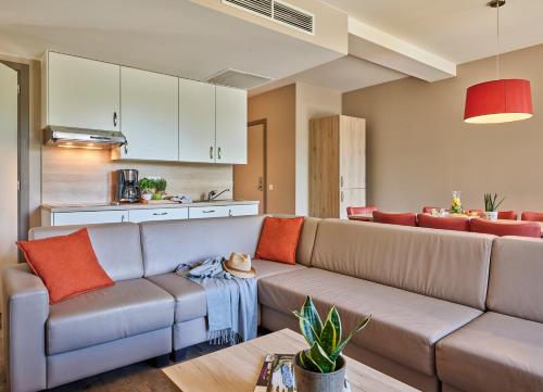 a living room with a couch and a kitchen at Holiday Suites Westende in Middelkerke