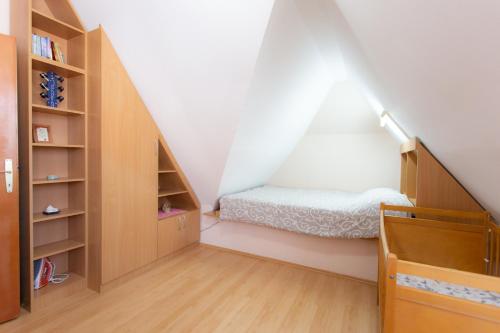 a small room with a bed and a book shelf at Apartman Sanja Divčibare in Divčibare