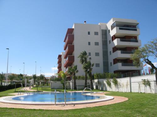 a swimming pool in a park in front of a building at Arenales Playa by Mar Holidays in Arenales del Sol