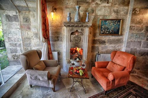 a living room with two chairs and a fireplace at Traveller's Cave Hotel in Göreme