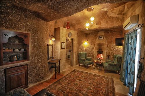 a large living room with a stone wall at Traveller's Cave Hotel in Goreme