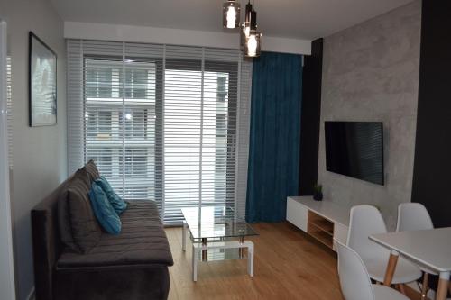 ein Wohnzimmer mit einem Sofa und einem Tisch in der Unterkunft Apartamenty DK9 Promenada Gwiazd 14 in Misdroy