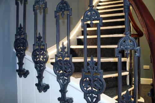 a set of stairs with blue wrought iron railings at CG Kensington in London