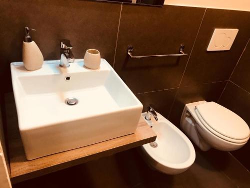 a bathroom with a white sink and a toilet at Sistra in Catania