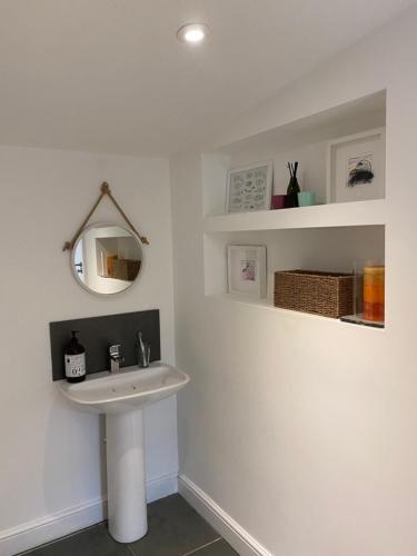 a white bathroom with a sink and a mirror at The Antidote in Ilfracombe