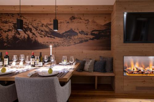 a dining room with a table and a fireplace at Brunnenhof Luxury Apartments in Lech am Arlberg