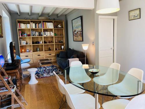 - un salon avec une table en verre et des chaises blanches dans l'établissement DRUIDES - Villa Familiale, Centre Plage - K51, à Carnac