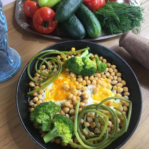 a plate of food with chickpeas and vegetables on a table at Apple Tree Family Home (ECO) in Dzorakap