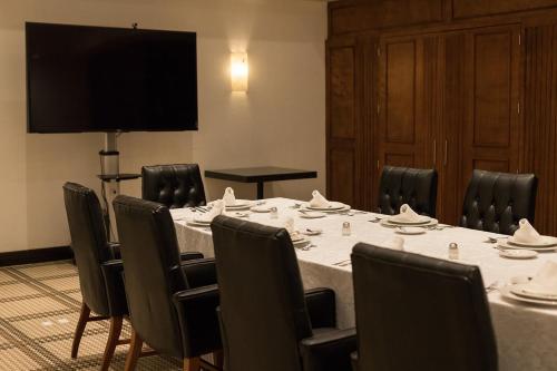 d'une salle de conférence avec une table, des chaises et une télévision à écran plat. dans l'établissement Hotel Leon, à León