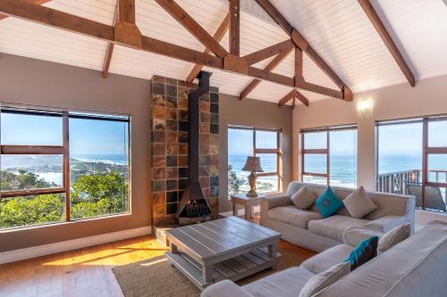 sala de estar con sofás y chimenea en Boardwalk Lodge – Self-Catering en Wilderness