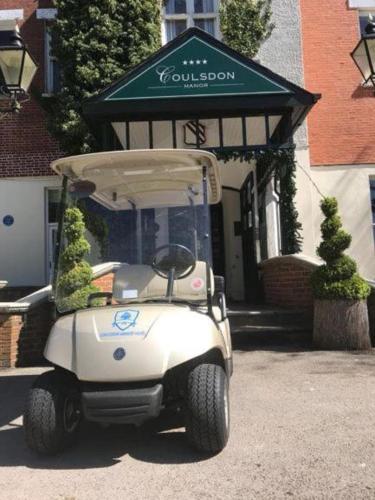 a white golf cart parked in front of a building at Coulsdon Manor Hotel and Golf Club in Croydon