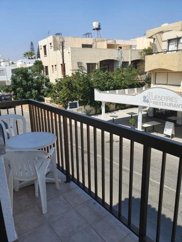 a balcony with a table and a white table and chairs at Sea CleoNapa Mandali in Ayia Napa