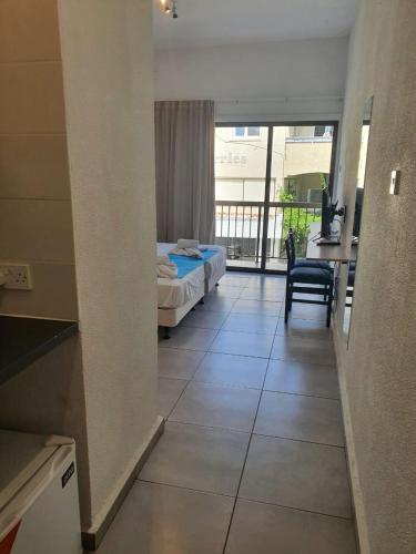 a bedroom with a bed and a table and a balcony at Sea CleoNapa Mandali in Ayia Napa