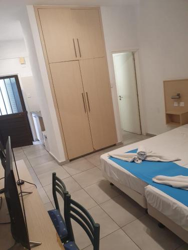 a room with two beds and chairs and a closet at Sea CleoNapa Mandali in Ayia Napa