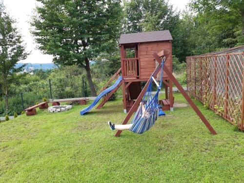 a playground with two swings in a yard at ŹRÓDLANE WZGÓRZE in Lesko