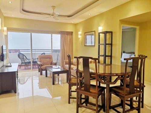ein Esszimmer und ein Wohnzimmer mit einem Tisch und Stühlen in der Unterkunft VIP Suite Seaview Batu Ferringhi 1003-2 Bedroom in Batu Feringgi